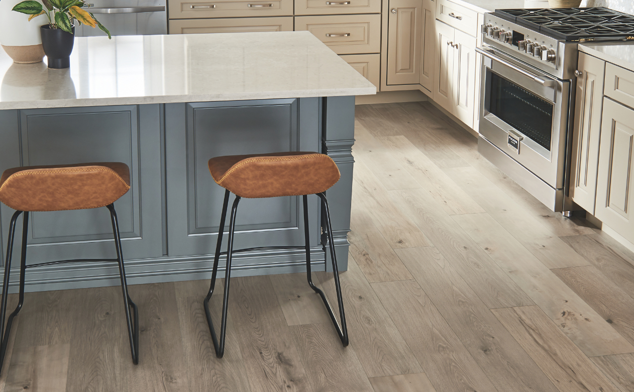 Kitchen with laminate flooring and a kitchen island with two barstools